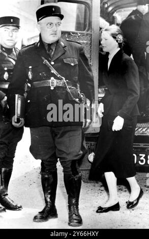 Française, Denise Labbe, blonde foncée de 30 ans arrive au palais de justice de Blois, escortée par des gendarmes, pour le procès conjoint qu'elle affronte avec son soldat amoureux de l'artillerie le lieutenant Jaques Algarron, 25 ans, pour le meurtre présumé de sa fille illégitime de 2 ans et demi. Blois, France, 30 mai 1956. Banque D'Images