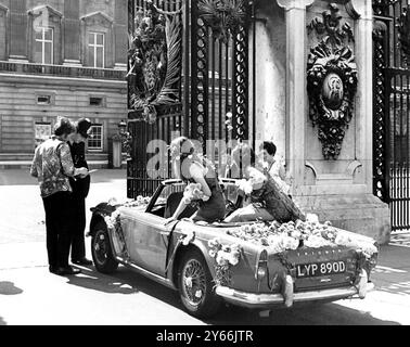 La reine a été invitée à l'amour international au palais Alexander. L'invitation est venue de trois hippies - un garçon et deux filles mini-jupe. Ils sont arrivés aux portes du palais de Buckingham dans la voiture psychédélique couverte de fleurs pour être accueillis Bya policier contstable qui a été montré l'invitation. Quelques instants plus tard, ils ont remis l'invitation à l'amour au Palace ... et ont laissé le policier avec l'emblème hippies - une fleur - - - - Buckingham Palace - 14 juillet 1967 Banque D'Images