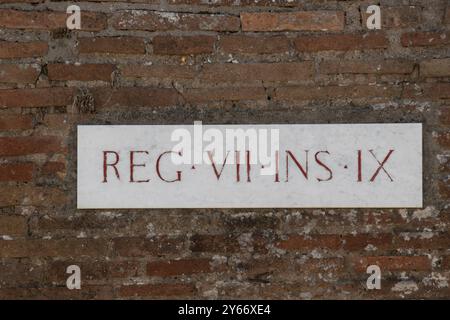 Panneau de rue sur un mur de briques rouges, Pompéi, Italie. Banque D'Images