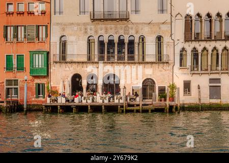 Les personnes qui apprécient les boissons au soleil sur la terrasse extérieure de l'Hôtel Venise Venise au Palazzo Ca’ da Mosto surplombant le Grand canal, Venise Banque D'Images