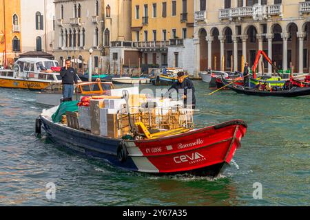 Un bateau de commerce motorisé sur chargé de marchandises fait son chemin le long du Grand canal à Venise, Italie Banque D'Images