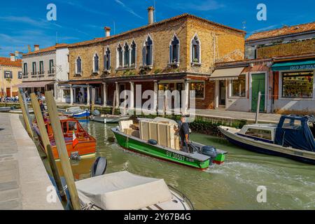 Un bateau contenant des caisses en bois contenant du verre de Murano fait son chemin le long de Rio dei Vetrai sur l'île de Murano, Venise, Italie Banque D'Images