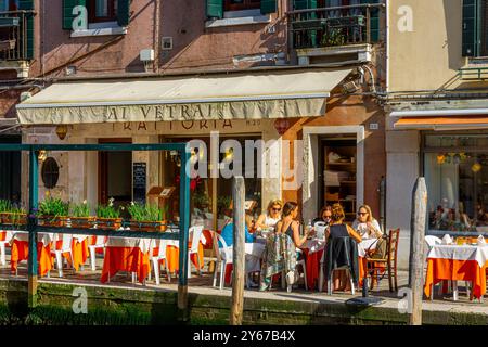 Un homme debout près d'un pilier dans un souterrain sur Fondamenta Maninnext à côté du Rio dei vetrai un canal sur l'île de Murano près de Venise, Italie Banque D'Images