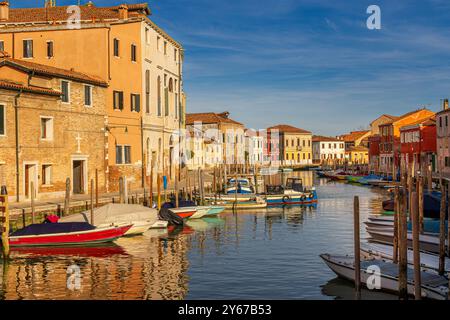 En fin d'après-midi, le soleil brille sur un canal le long de Fondamenta Sebastiano Santi sur l'île de Murano près de Venise, en Italie Banque D'Images