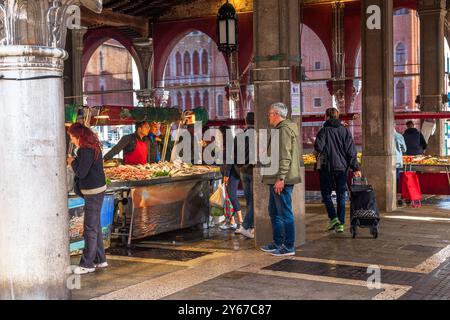 Les gens qui achètent du poisson frais au marché aux poissons Rialto dans le sestiere San Polo de Venise, Italie Banque D'Images