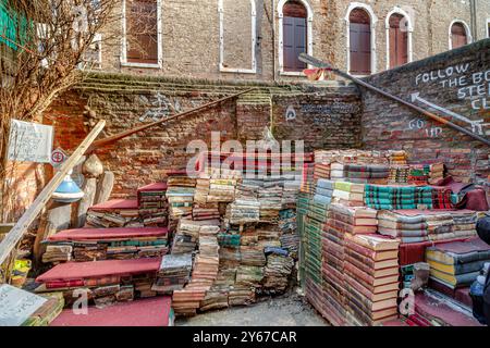 Marches faites à partir de vieux livres pour permettre aux gens de regarder par-dessus le mur à l'arrière de Liberia Acqua Alta , une librairie excentrique et populaire à Venise, en Italie Banque D'Images