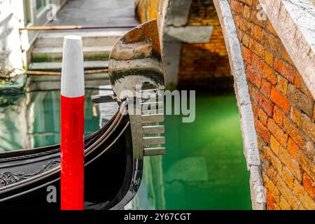 Gros plan d'une lame de métal hhe ou fero da prora sur le devant d'une gondole au Ponte dei Ferali dans le sestiere San Marco de Venise, Italie Banque D'Images