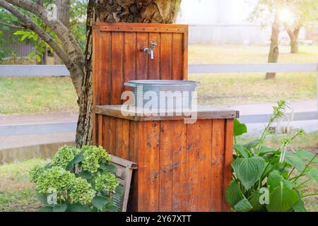 Lavabo dans le village à l'extérieur. Se laver les mains dans le jardin rustique en journée ensoleillée. Cottage jardin. Banque D'Images