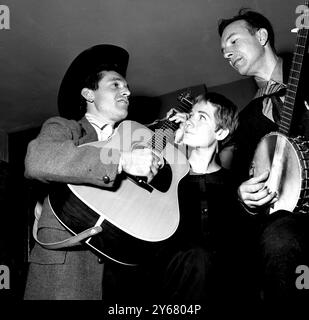 Jack Elliott (à gauche) et Pete Seeger (à droite) ont une séance d’entraînement avant de commencer leur tournée en Grande-Bretagne. Hootenanney est mieux connu sous le nom de musique folk, et Seeger vient de terminer une étude de deux ans sur Folk Lore avec sa femme japonaise, Toshi. Au centre, June Elliott épouse de Jack qui a abandonné une carrière cinématographique pour gérer son mari. Londres - 27 septembre 1959 Banque D'Images