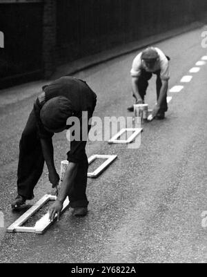 Les autorités du Kent ont accéléré les panneaux de signalisation routière sur toutes les routes secondaires pour aider les conducteurs en cas d'interdiction générale. La photo montre des hommes avec des pochoirs connectés par lesquels ils sont capables de peindre des lignes blanches sur le centre de la route - rapidement et en ligne droite, à Bexley, Kent. 28 août 1939 Banque D'Images