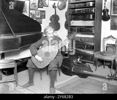 Préparation pour Haslemere Festival of Old Chamber Music. Famille célèbre qui fabriquent des instruments de vieux temps. M. Arnold Dolmetsch dans sa salle de musique est vu jouer du luth . 23 janvier 1925 Banque D'Images