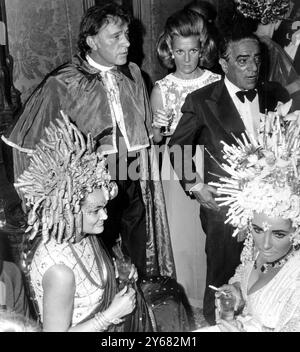 Vu au bal masqué au Palais Rezzonico, Venise 9 septembre 1967, Richard Burton (debout à gauche avec le cap) Elizabeth Taylor (au premier plan à droite), la comtesse Marina Cicogna (debout) et Aristote Onassis. La dame au premier plan gauche n'est pas identifiée. Banque D'Images