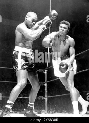 Doug Jones (à gauche) lève les mains alors que Cassius Clay laisse voler avec un rond-point à droite lors de leur combat de 10 tours poids lourds Contenders à Madison Square Garden, New York. Clay, qui avait prédit une victoire rapide à élimination directe, a dû se contenter d'une décision unanime sur Jones sur les points. 13 mars 1963. Banque D'Images