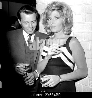 L'acteur britannique Dirk Bogarde s'est vu confier le rôle du méchant dans le film Modesty Blaise du 20th Century Fox, dont le rôle-titre, l'actrice italienne Monica Vitti, apparaîtra. Monica et Dirk ont eu une rencontre amicale ce soir autour de cocktails au Savoy Hotel de Londres. Modesty Blaise est basé sur la bande dessinée du même nom, créée par Peter O'Donnel qui est présentée dans un journal du soir londonien et est syndiquée à l'étranger dans quatorze grands journaux. Le film pourrait bien devenir la réponse féminine à 'James Bond'. Le travail de production sur Modesty commence à Amsterdam la semaine prochaine et se déplace ensuite vers S. Banque D'Images