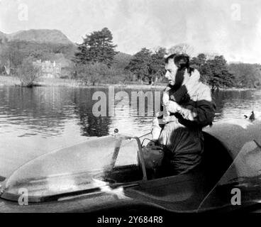 Coniston Water : Donald Campbell, âgé de 36 ans, vient de battre son propre record mondial de vitesse sur l'eau dans son Bluebird propulsé à réaction, voyageant à une vitesse moyenne de 239,07 mph. Comment il a le droit de se rafraîchir et de se dépouiller de certains de ses vêtements! Son précédent record était de 225,63 mph. Il a fait la tentative vers 10 heures ce matin après que la brume s'était dissipée, surveillé par sa sœur Jean. Sa mère, Lady Campbell, a séjourné dans son hôtel près du lac, mais est allée féliciter son fils par la suite. 7 novembre 1957 Banque D'Images