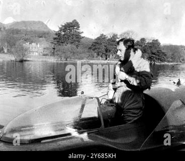 Coniston Water : Donald Campbell, âgé de 36 ans, vient de battre son propre record mondial de vitesse sur l'eau dans son Bluebird propulsé à réaction, voyageant à une vitesse moyenne de 239,07 mph. Comment il a le droit de se rafraîchir et de se dépouiller de certains de ses vêtements! Son précédent record était de 225,63 mph. Il a fait la tentative vers 10 heures ce matin après que la brume s'était dissipée, surveillé par sa sœur Jean. Sa mère, Lady Campbell, a séjourné dans son hôtel près du lac, mais est allée féliciter son fils par la suite. 7 novembre 1957 Banque D'Images