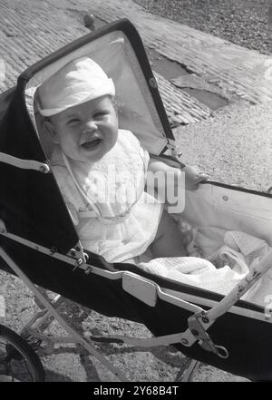 années 1960, historique, enfant nourrisson assis dans la poussette pliante en métal de l'époque. Banque D'Images