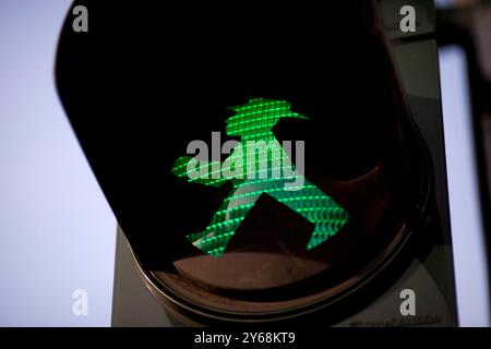 Un signal piétonnier vert Ampelmännchen brille à Berlin est, invitant les marcheurs à traverser la rue en toute sécurité. Banque D'Images