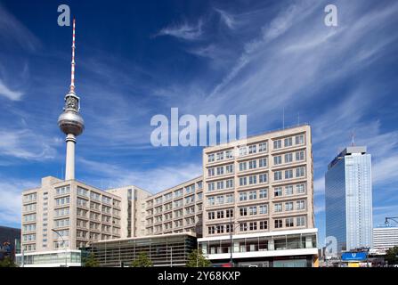 Les visiteurs admirent les monuments emblématiques de la place Alexanderplatz à Berlin sous un ciel bleu clair. Banque D'Images