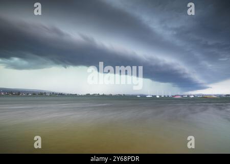 Formation spectaculaire de nuages, nuages de plateau, et un soupçon de pluie au-dessus d'un lac avec des bateaux visibles à l'horizon, Allensbach, Untersee, lac de Constance, Constan Banque D'Images