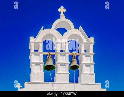 Petit beffroi blanchi à la chaux contre ciel bleu clair. Église orthodoxe traditionnelle dans les îles Cyclades, mer Égée, Grèce. Banque D'Images