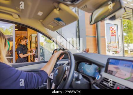 McDrive chez McDonald's avec serveur qui remet la commande au client en voiture. Suède. Stockholm. Banque D'Images
