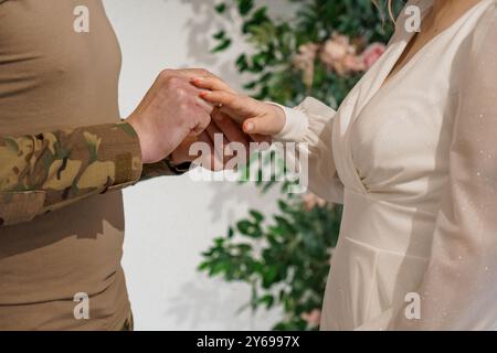 Moment tendre entre un couple dans un cadre de mariage intime entouré de beaux arrangements floraux. Banque D'Images