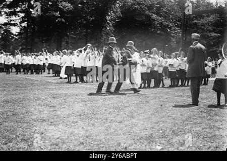 Réalisant une fille qui s'est évanouie, passer le relais de balle, photographie montre des filles des écoles secondaires Washington Irving, New York, assistant à un festival de la journée d'été qui a eu lieu à Pelham Bay Park dans le Bronx le 23 juin 1911., 1911 juin 23, enfants, négatifs en verre, 1 négatif : verre ; ou plus petit. Banque D'Images