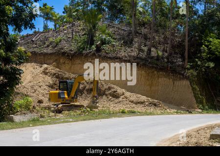 Excavatrice sur la construction d'une route à travers la jungle tropicale Banque D'Images