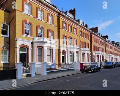 Rue des maisons de ville en briques jaunes avec garniture rouge autour des fenêtres Banque D'Images