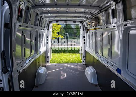 Transporteur local industriel compact blanc manoeuvrable et économique mini van cargo avec porte arrière ouverte prêt à charger les prochaines marchandises pour la livraison standing o Banque D'Images