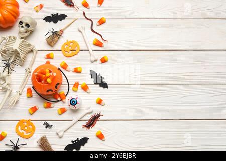 Composition d'Halloween avec des jouets et des bonbons sur fond de bois blanc Banque D'Images