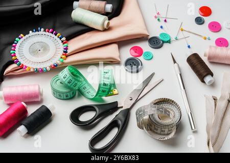 Artisanat essentiels pour les projets de couture affichés sur une table avec du tissu, des fils et des outils Banque D'Images