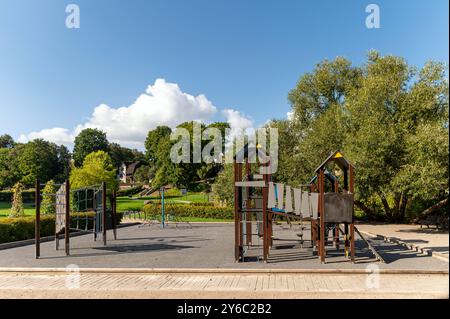 L'aire de jeux pour enfants dispose d'équipements d'escalade et de toboggans dans un parc verdoyant et ensoleillé. Banque D'Images