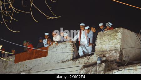 Agra, Uttar Pradesh, Inde. Les musulmans indiens regardent la cérémonie de mariage depuis le toit de la maison. Cortège indien de mariage hindou de Baraat. Procession du marié Banque D'Images