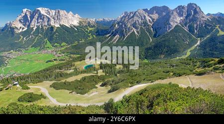 Montagnes de Wetterstein avec Zugspitze (à gauche 2962 m), Mieminger Kette avec Sonnenspitze (2417 m) et Tajakopf (2450 m) vu de Grubigstein au-dessus de Lermoos. Les villages d'Ehrwald et Lermoos dans la vallée. Le pâturage de montagne Grubigalm au premier plan. Tyrol, Autriche Banque D'Images