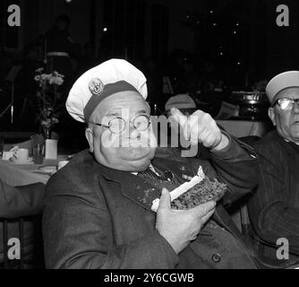 10 DÉCEMBRE 1963 - - HARRY ELLIS DE LA MAISON ÉTOILE ET JARRETIÈRE POUR LES EX-MILITAIRES HANDICAPÉS MANGEANT UN GÂTEAU DE NOËL À LA FÊTE DE NOËL DE LA NOT FORGOTTEN ASSOCIATION À L'ÉCOLE D'ÉQUITATION ROYALE, BUCKINGHAM PALACE, LONDRES, ANGLETERRE. Banque D'Images