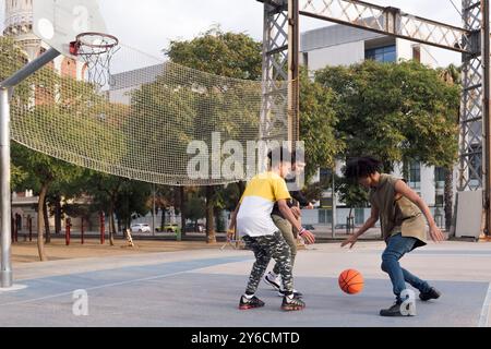amis adolescents multiethniques jouant au basket-ball Banque D'Images
