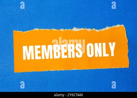 Les membres seulement le message écrit sur un papier orange déchiré déchiré avec un fond bleu. Symbole membres conceptuels uniquement. Copier l'espace. Banque D'Images