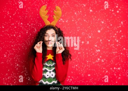 Photo de drôle de dame moustache avec un curl agissant aimé guy veulent gagner concours de costume porter le chandail avec cornes rouge isolé de l'arbre vert Banque D'Images