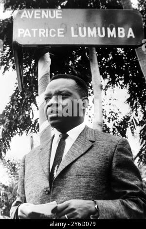 27 SEPTEMBRE 1963 CYRILLE ADOULA, LE PREMIER MINISTRE DE LA RÉPUBLIQUE DÉMOCRATIQUE DU CONGO, DANS UN PORTRAIT RÉCENT DEBOUT SOUS UNE PANCARTE POUR L'AVENUE PATRICE LUMUMBA, LE PREMIER PREMIER MINISTRE EXÉCUTÉ. LEOPOLDVILLE, CONGO. Banque D'Images