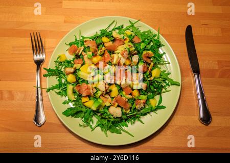 Salade fraîche et saine avec mangue, avocat, saumon, roquette et croûtons sur une table en bois Banque D'Images