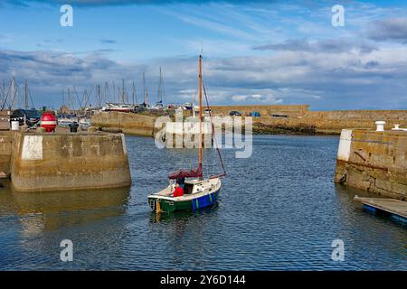 Lossiemouth Moray Firth Écosse à la fin de l'été un petit yacht avec des marins quittant le port Banque D'Images