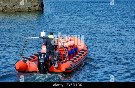 Lossiemouth Moray Firth Écosse à la fin de l'été rouge bateau gonflable Mutineer avec des passagers quittant la marina Banque D'Images