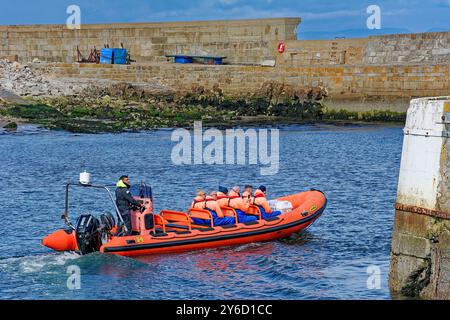 Lossiemouth Moray Firth Écosse à la fin de l'été rouge bateau gonflable Mutineer avec six passagers quittant la marina Banque D'Images