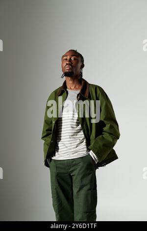 Un jeune homme afro-américain met en valeur son sens unique de la mode avec une veste et un pantalon verts. Banque D'Images