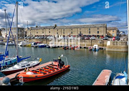 Lossiemouth Moray Firth Écosse fin d'été rouge bateau gonflable Mutineer dans la marina avec Harbour Lights Cafe dans Pitgaveny Street Banque D'Images