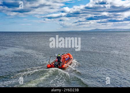 Lossiemouth Moray Firth Écosse fin d'été rouge bateau gonflable Mutineer avec des passagers quittant la marina pour la mer ouverte Banque D'Images