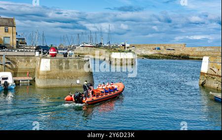 Lossiemouth Moray Firth Écosse fin d'été rouge bateau gonflable Mutineer avec des passagers quittant la marina Banque D'Images