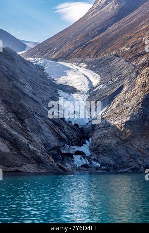 Glacier suspendu dans le fjord de Dickson, parc national du nord-est du Groenland, Arctique. Montagnes montantes et eaux bleues froides du fjord. Banque D'Images
